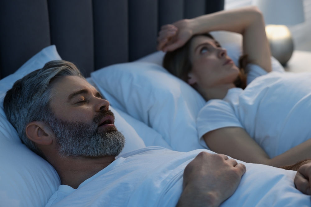 Links Between Sleep, Alzheimer’s Disease, and Sex Differences as shown by a couple sleeping in bed